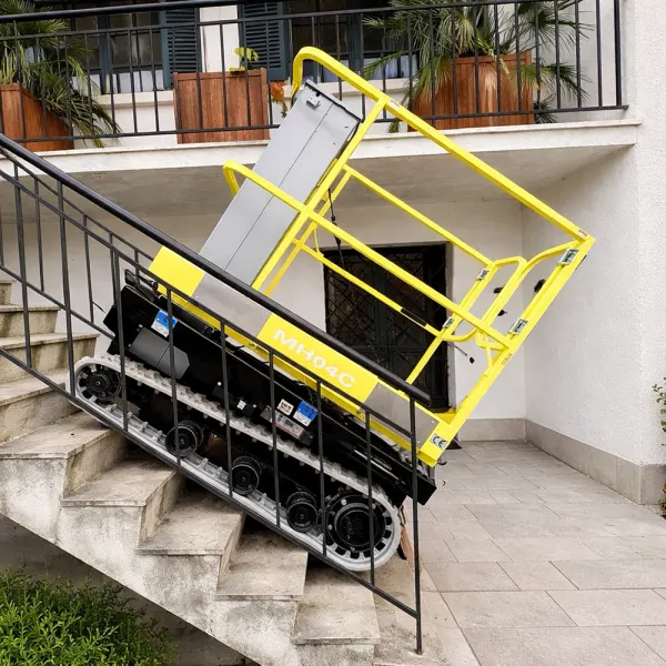 Nacelle sur chenilles Microlev 400 descendant l'escalier extérieur d'une maison, entre deux rampes